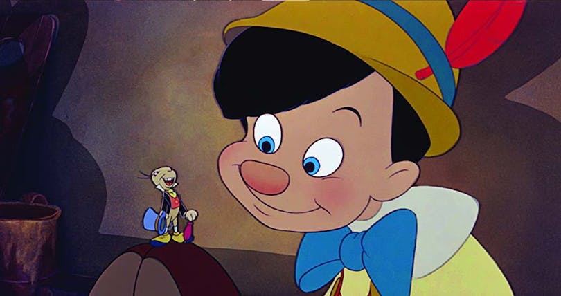 Pinocchio sitter ner på golvet och tittar på Benjamin syrsa i Disneys klassiker.